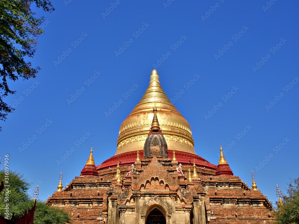 Fototapeta premium The entrance arch with golden stupa of the Dhammayazika pagoda, one of the famous landmark of Bagan, Myanmar