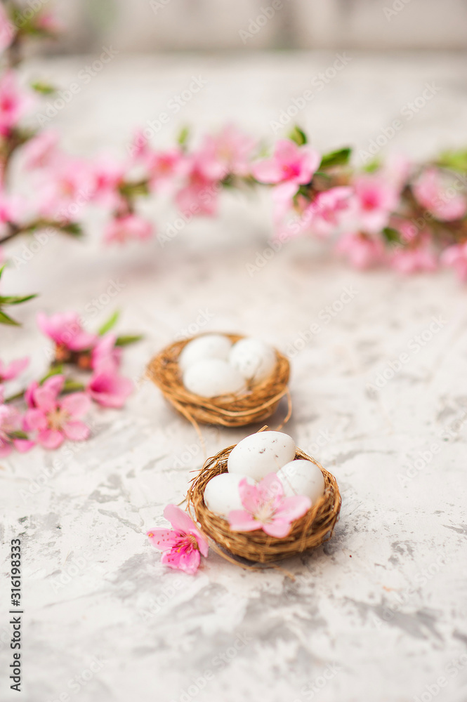 Spring photo of a blossoming tree and Easter eggs close-up and copy space. Easter card concept with bunny and eggs. Trending pink shades.