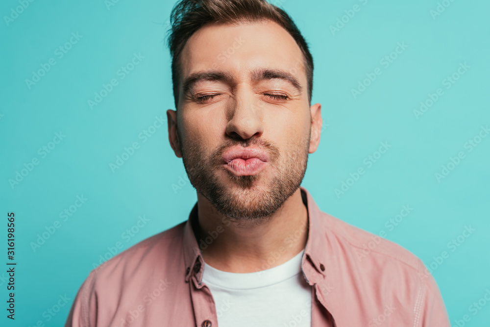 happy handsome man with closed eyes making air kiss isolated on blue happy handsome man with closed eyes making air kiss isolated on blue