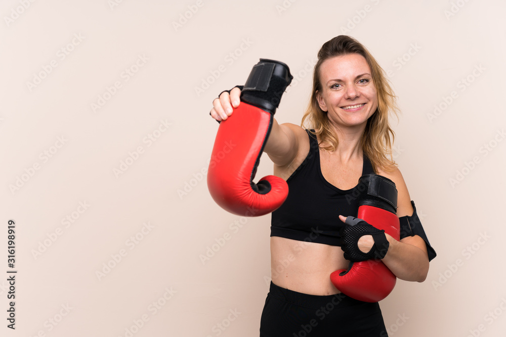 Blonde sport woman over isolated background with boxing gloves Blonde sport woman over isolated background with boxing gloves