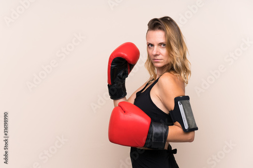 Blonde sport woman over isolated background with boxing gloves