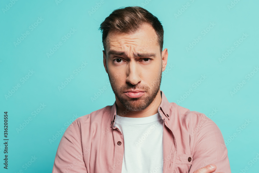 skeptical handsome man looking at camera, isolated on blue skeptical handsome man looking at camera, isolated on blue