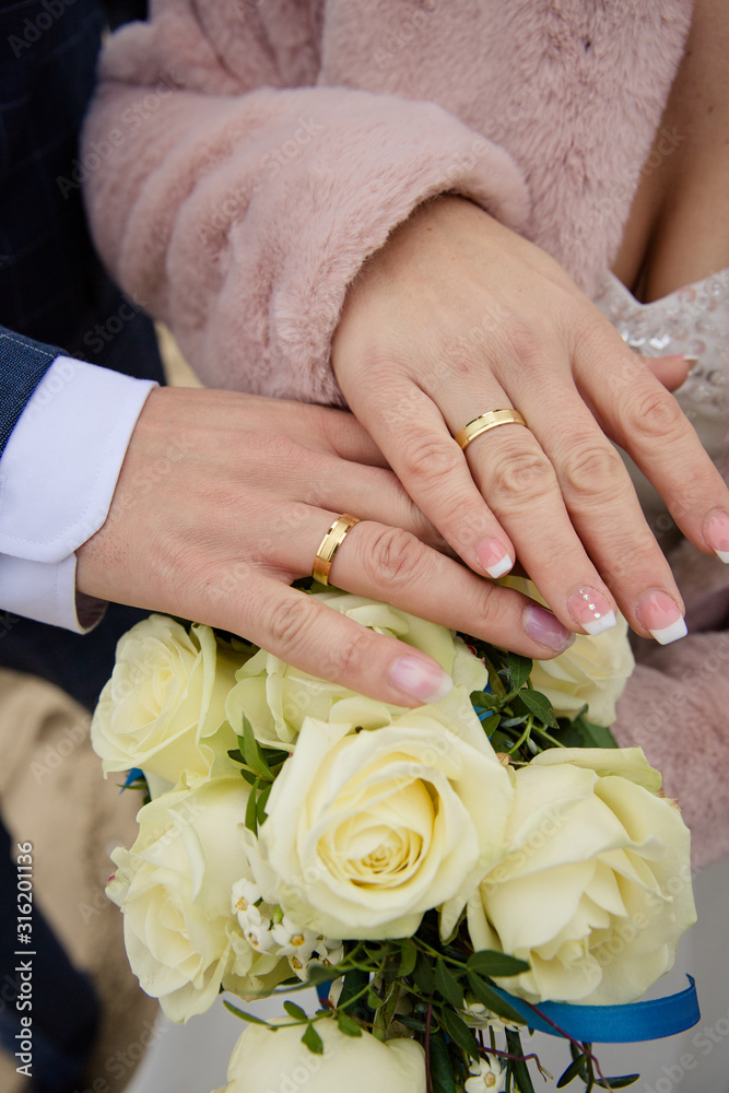 Brautpaar mit goldenen Eheringen und Brautstrauß mit weißen Rosen Brautpaar mit goldenen Eheringen und Brautstrauß mit weißen Rosen