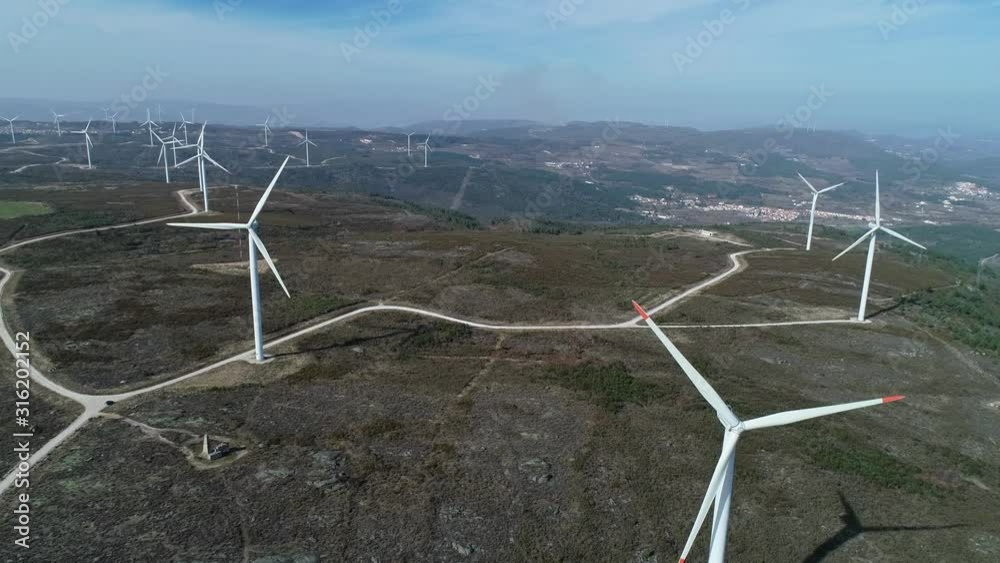 Aerial view of windmills or wind turbine on wind farm in rotation to generate electricity energy, 4k
