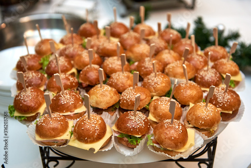 Buffet table with mini hamburgers at luxury wedding reception, copy space. Serving food and appetizers at restaurant. Catering banquet table