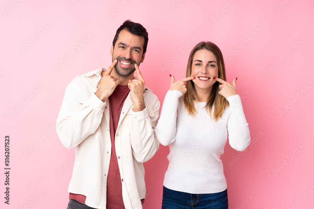 Couple in Valentine Day over isolated pink background smiling with a happy and pleasant expression Couple in Valentine Day over isolated pink background smiling with a happy and pleasant expression