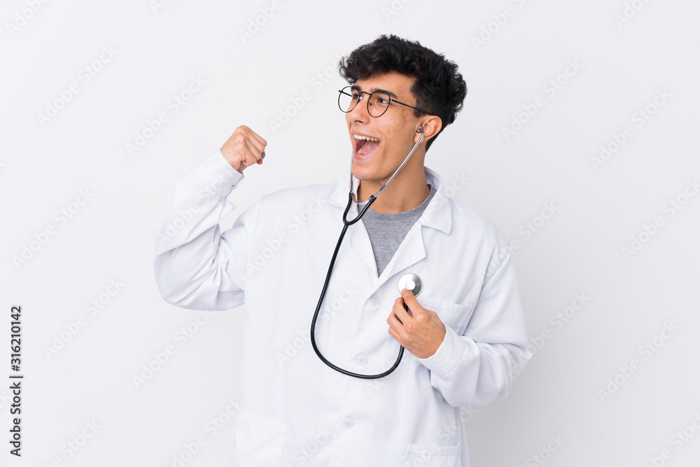 Fototapeta premium Young Argentinian man over isolated white background wearing a doctor gown and with stethoscope
