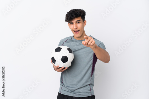 Argentinian football player man over isolated white background surprised and pointing front © luismolinero
