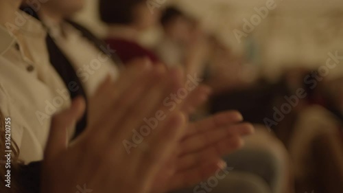 Clapping hands in the opera. Close up view of clapping people hands in the modern filharmonia building interior