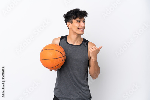 Basketball player man over isolated white background pointing to the side to present a product