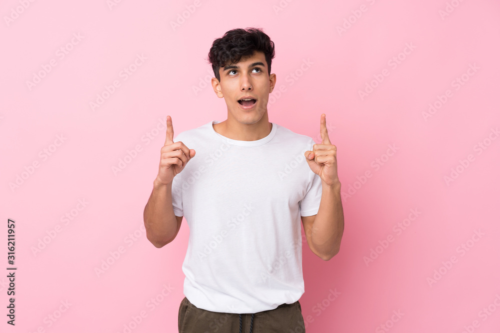 Young Argentinian man over isolated pink background pointing with the index finger a great idea Young Argentinian man over isolated pink background pointing with the index finger a great idea