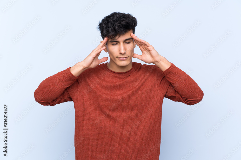Young Argentinian man over isolated blue background with headache Young Argentinian man over isolated blue background with headache