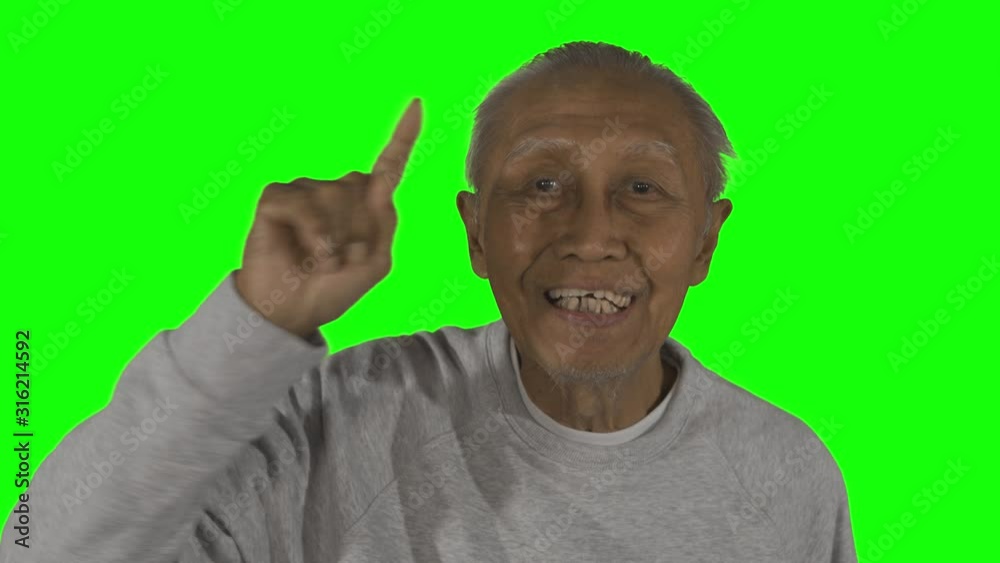 Elderly man smiling and pointing at the camera while standing the camera in the studio. Shot in 4k resolution Elderly man smiling and pointing at the camera while standing the camera in the studio. Shot in 4k resolution