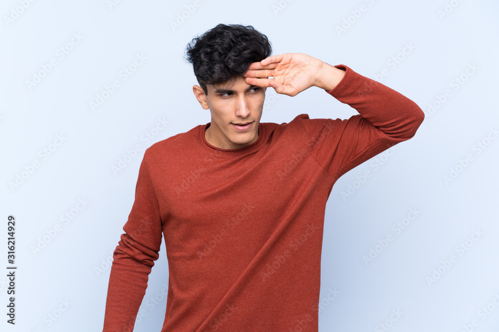 Young Argentinian man over isolated blue background with tired and sick expression Young Argentinian man over isolated blue background with tired and sick expression