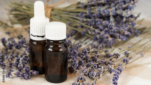 aromatherapy, lavender flowers with a bottle of essential oil on the table close-up
