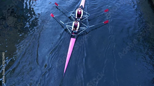 Rowboat with unrecognizable rowers seen from above.