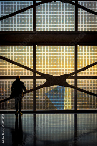 silhouette of man standing in front of a new building with photovoltaic technologies in Milan