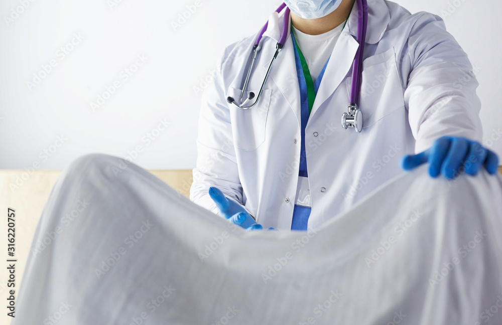 male obstetrician and scrubs nurse are delivered to the pregnant woman in the delivery room of the hospital