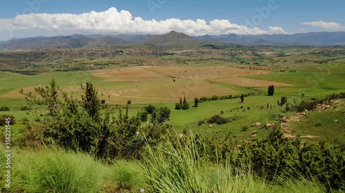 Maloti mountain range and farms in Free-state province near Clarens town and the Lesotho border. Roadside grass and flowers moving in the wind. photo