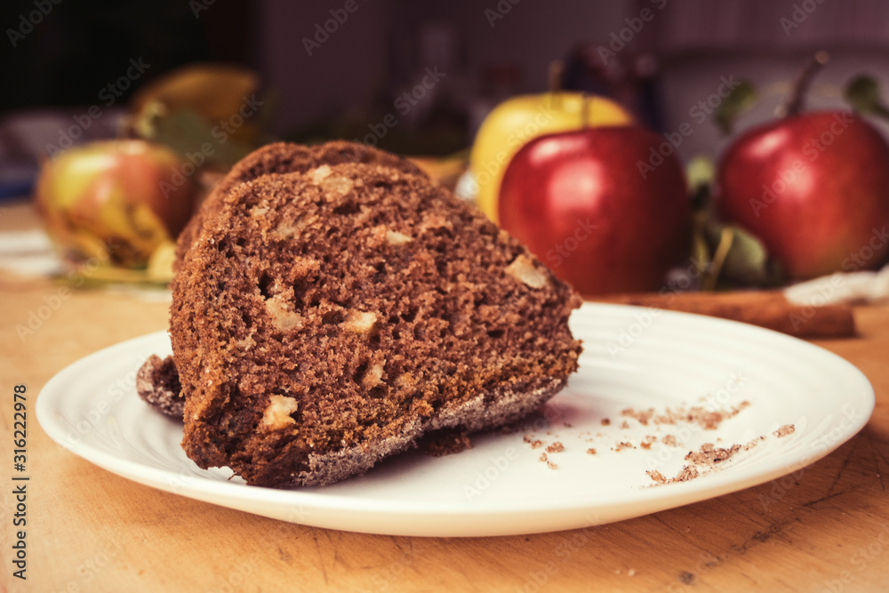 Sliced apple cinnamon bread with decorations on wooden table. Made from apples, sugar, oil, eggs, flour. Homemade apple loaf cake on plate with fresh apples and cinnamon in background at autumn Sliced apple cinnamon bread with decorations on wooden table. Made from apples, sugar, oil, eggs, flour. Homemade apple loaf cake on plate with fresh apples and cinnamon in background at autumn
