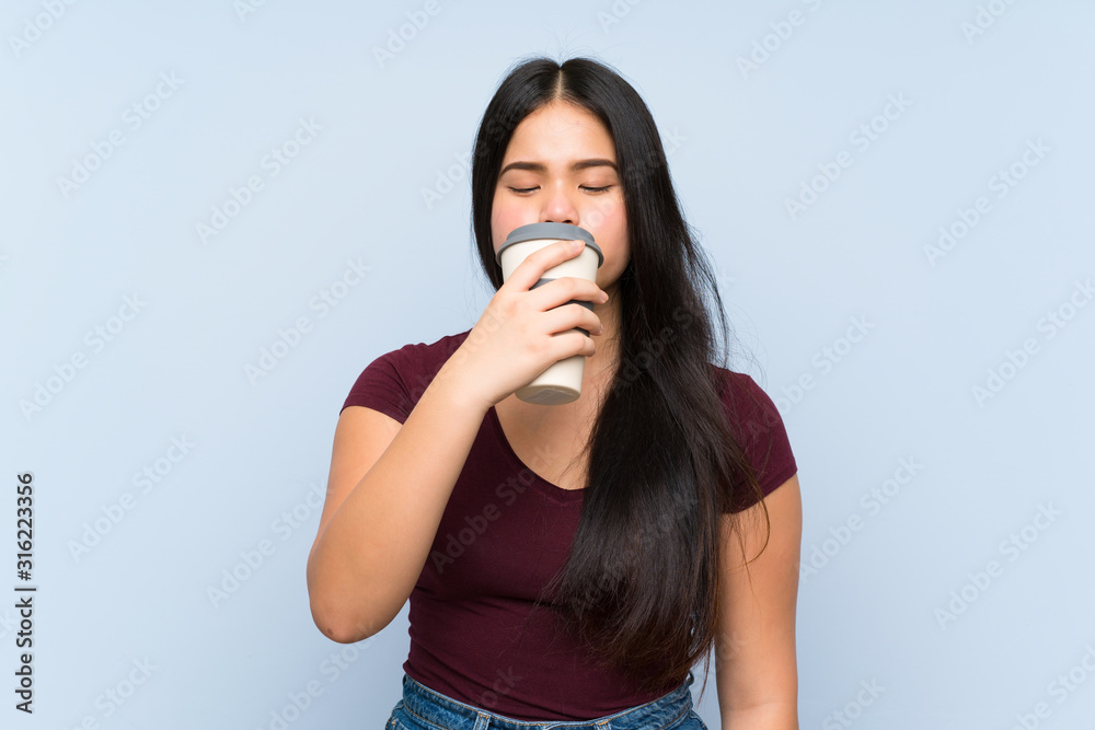 Young teenager Asian girl holding a take away coffee Young teenager Asian girl holding a take away coffee