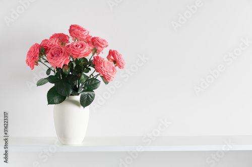 Beautiful flowers, pink roses. Roses in vase on shelf against white wall. Valentines Day, Easter, Happy Women's Day, Mother's day. Space for text. © prime1001