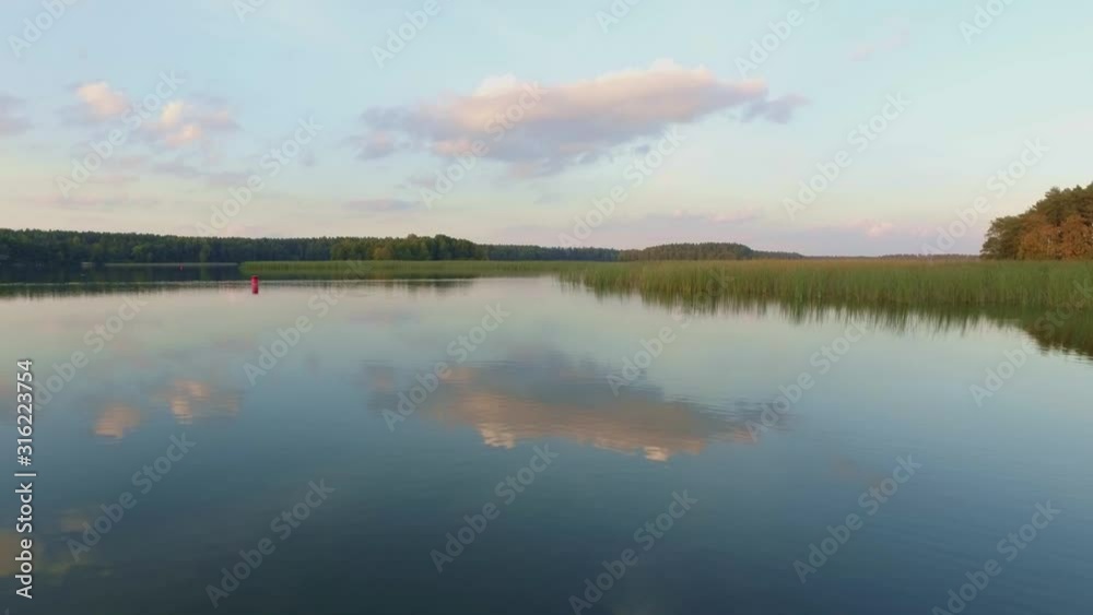 Aerial low flight avove calm lake during golden hour, Suwalszczyzna, Poland, towards rising shot Aerial low flight avove calm lake during golden hour, Suwalszczyzna, Poland, towards rising shot