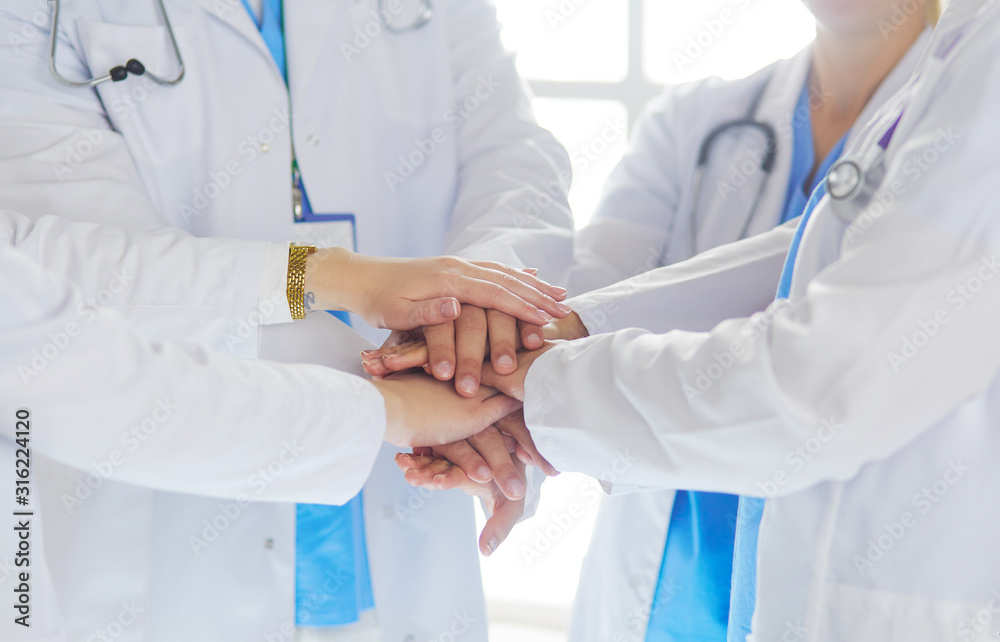 Doctors and nurses stacking hands. Isolated on white Doctors and nurses stacking hands. Isolated on white