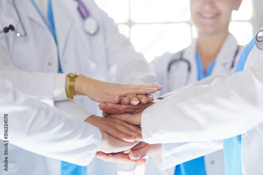 Doctors and nurses in a medical team stacking hands