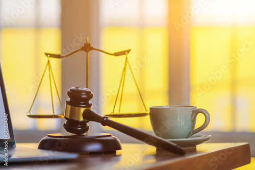 The mallet and brass scales are placed on the table in the lawyer's office for decorative purposes and are a symbol of justice in court decisions. photo