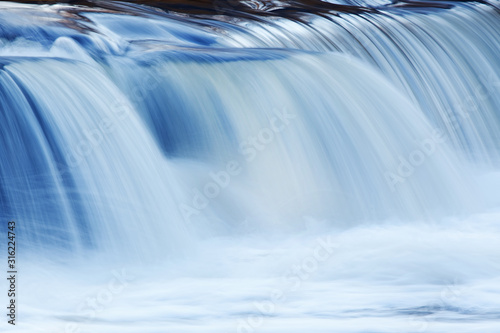 Landscape captured with blurred motion of a cascade on the Rabbit River, Michigan, USA