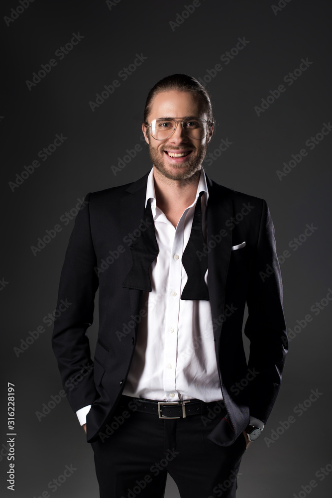 cheerful handsome man in suit and tie bow isolated on grey cheerful handsome man in suit and tie bow isolated on grey