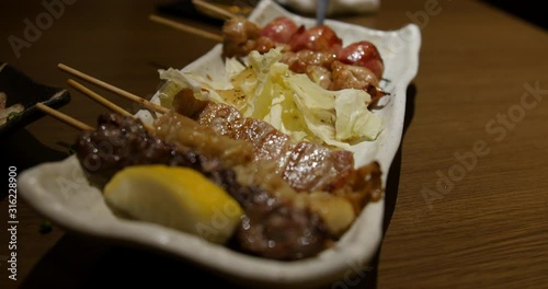 Yakitori is a Japanese type of skewered chicken. Its preparation involves skewering the meat with kushi a type of skewer.  the meat is typically seasoned with tare sauce or salt photo