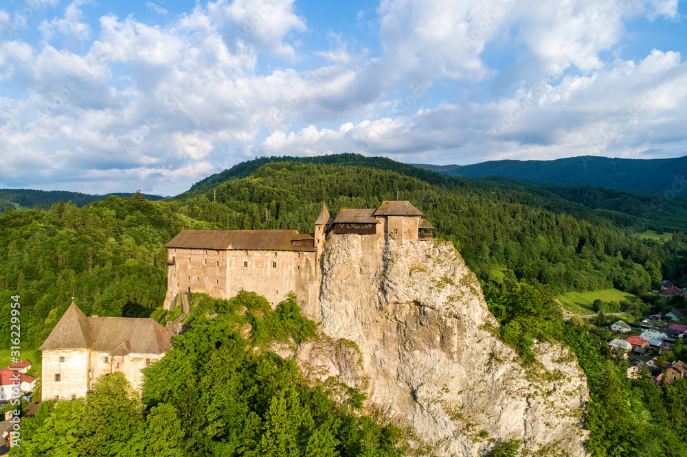 Orava castle - Oravsky Hrad in Oravsky Podzamok in Slovakia. Medieval stronghold on extremely high and steep cliff. Aerial view in sunrise light