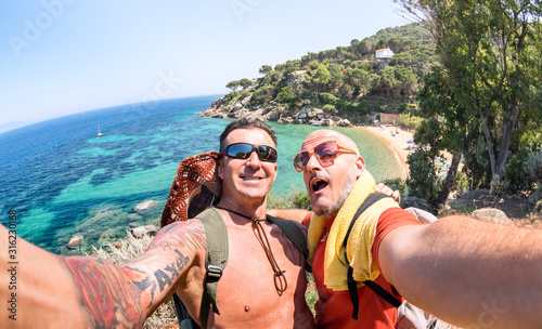 Best friends taking selfie at Giglio Island on adventure travel - Wanderlust lifestyle concept with gay couple enjoying happy fun moment - Trip together around world beauties - Bright vivid filter photo