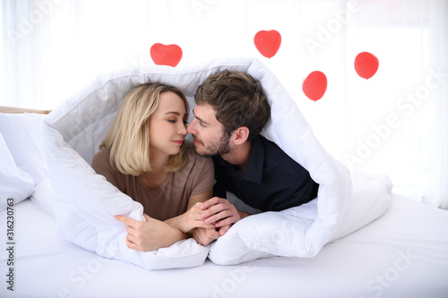 Cute young couples smiling under blanket with love mood.