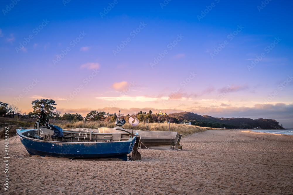 2 Fischerboote am Strand mit Steilküste im Hintergrund vor beginnendem Abendrot