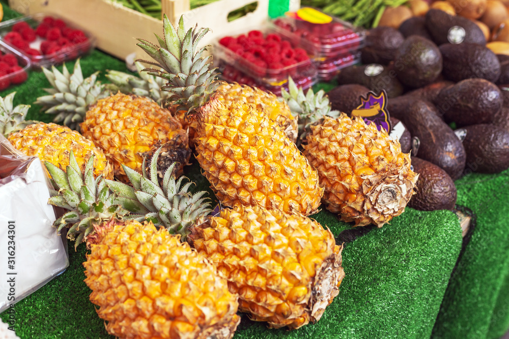 Different kinds of tropical fruits at market. Pineapple, avocado, raspberry. Fresh raw organic bio uncooked fruits for sale at farmers market. stock photo of fruits vegan food, healthy nutrition. Different kinds of tropical fruits at market. Pineapple, avocado, raspberry. Fresh raw organic bio uncooked fruits for sale at farmers market. stock photo of fruits vegan food, healthy nutrition.