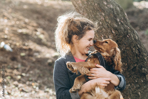 Candid portrait of attractive young emotional woman with her beautiful brown english cocker spaniel dog