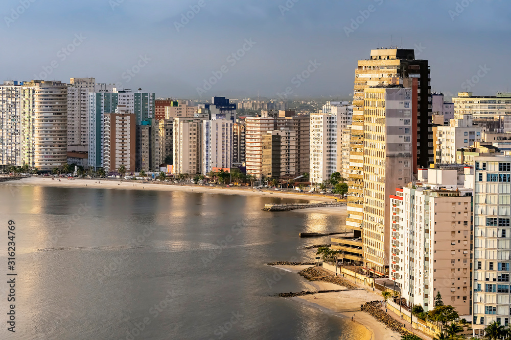 Fototapeta premium Tall buildings near to the beach of a coastal city during the day. Paulista coast, Sao Vicente city - SP Brazil.
