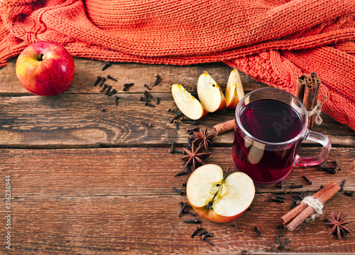 Fototapeta Naklejka Na Ścianę i Meble -  Christmas hot mulled wine with spices and fruits on a old wooden background. Autumn background, Christmas background. Text space.