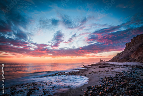 Beautiful beach sunset with a rocky shore