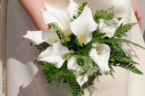 Foto Elegante ramo de flores de alcatraz blanco en la mano de una novia