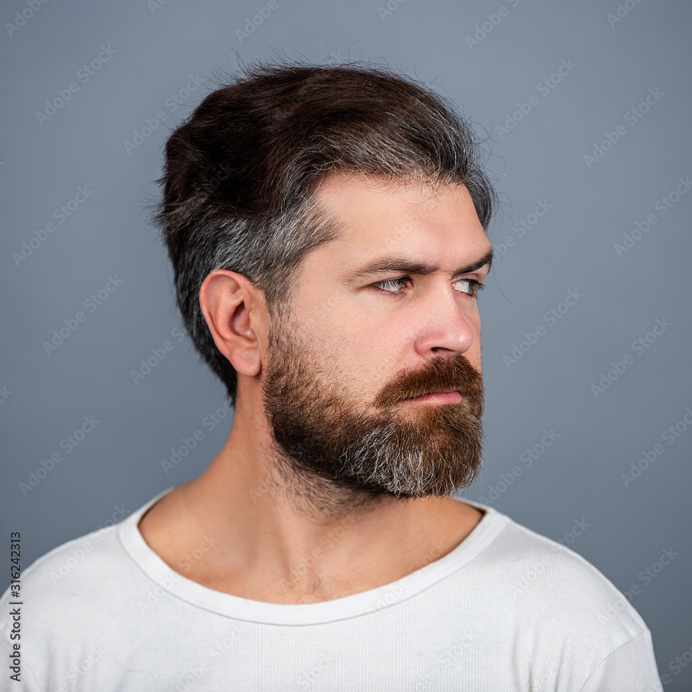 Obraz premium Sexy gorgeous stylish man. Close up portrait of a handsome young man. Portrait of handsome man against grey wall.