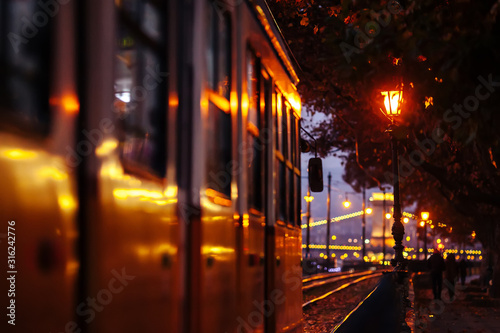 A yellow tram travels on route number 2 along the banks of the Danube. Cloudy autumn evening in Budapest.
