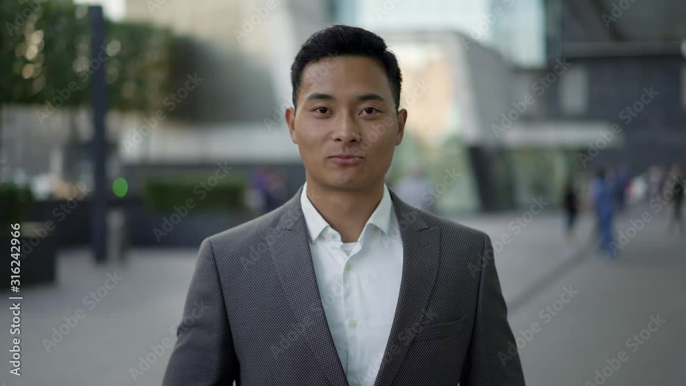 Real time portrait shot of a young happy Asian businessman smiling. Real time portrait shot of a young happy Asian businessman smiling.