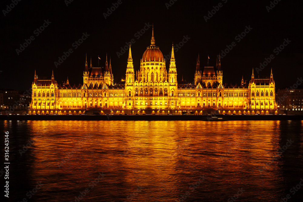 Night view of the Hungarian Parliament building in Budapest. Beautiful lighting and reflection in the Danube river.