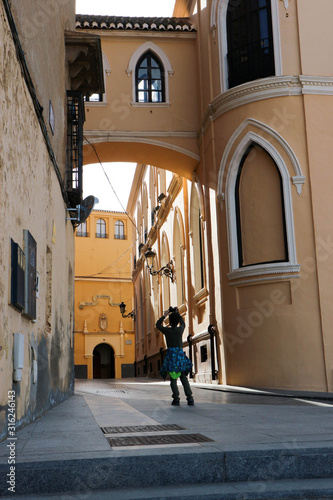 Young boy photographer make a photo of beautiful street in Guadix, Andalucia, Spain