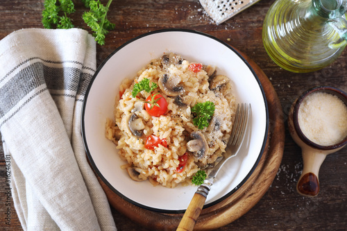Italian cuisine. Plate of mushroom risotto with cherry tomatoes and parmesan cheese