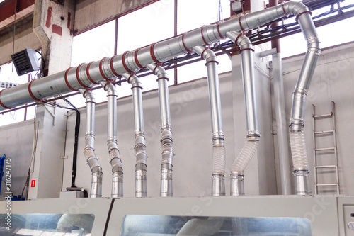 Ducts and pipes of an industrial aspiration system at a woodworking and sawmill factory. photo